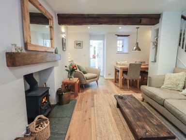 A living room with a fireplace and dining area at Daffodils in Ambleside