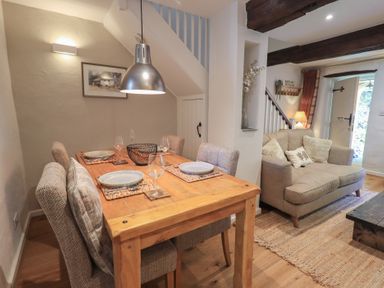 A dining room with a table and chairs and a sofa at Daffodils in Ambleside