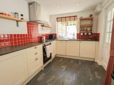 A kitchen with red tiles and appliances at Daffodils in Ambleside
