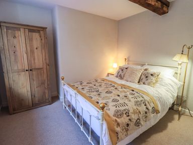 A bedroom with a bed and wardrobe at Daffodils in Ambleside