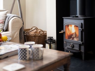A living room with a fireplace and sofa at Driftwood in Embleton