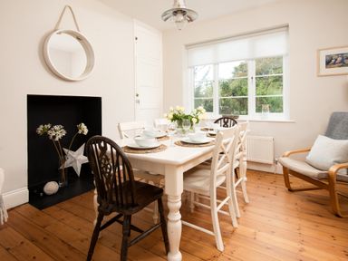 A dining room with a table and chairs at Driftwood in Embleton
