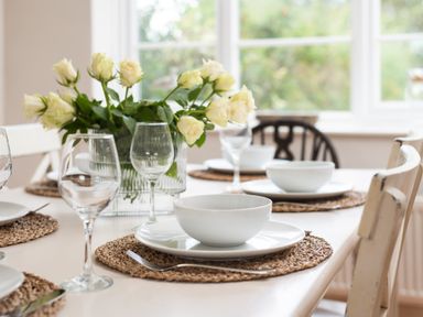 A dining table set with plates and glasses at Driftwood in Embleton