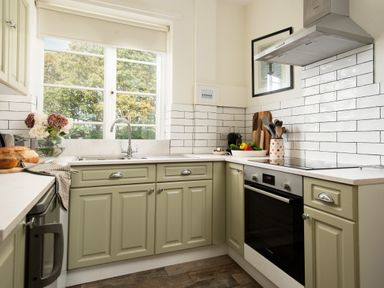 A kitchen with cabinets and a sink at Driftwood in Embleton