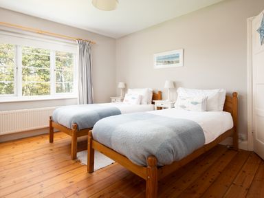 A bedroom with two beds and a window at Driftwood in Embleton