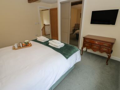 A bedroom with a bed, drawer cabinet, and television at 1 Brookside in Warcop