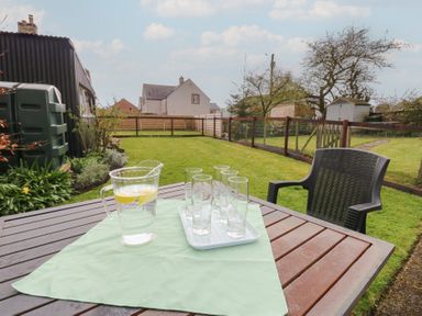 A table with a pitcher and glasses in a garden at 1 Brookside Warcop