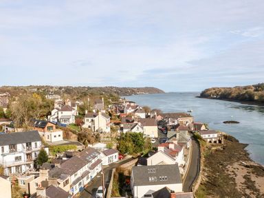 A coastal village with houses along a river and a road by the shore at Ty Chwarel in Menai Bridge