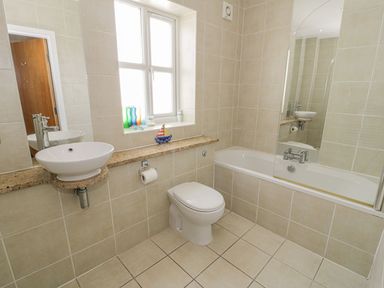 A bathroom with a sink toilet and bathtub at Seaview in Benllech near Red Wharf Bay