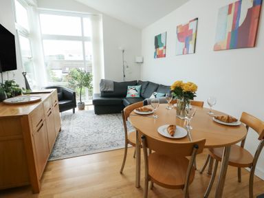 A dining room with a table set for breakfast at Seaview in Benllech near Red Wharf Bay