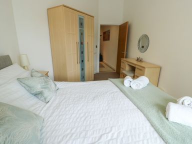 A bedroom with a bed and wardrobe at Seaview in Benllech near Red Wharf Bay
