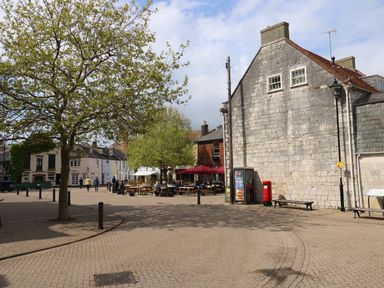 An outdoor area with benches and a tree at Apartment 1 Brewers Quay in Weymouth
