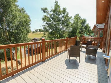 An outdoor area with chairs on the deck at Finnbars Lodge in Richmond
