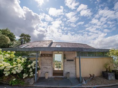 The exterior entrance of a house with plants and flowers on each side at Curlew House in Cosheston