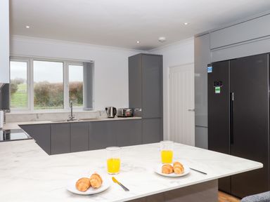 A kitchen with a marble countertop with plates of croissants and glasses of orange juice at West View in Northlew near Hatherleigh