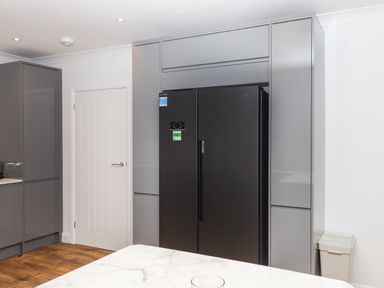 A kitchen with a black double door refrigerator, grey cabinets, a white door, and a marble countertop at West View in Northlew near Hatherleigh