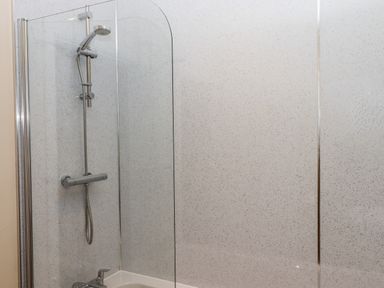 A bathroom with a showerhead and a glass shower screen at West View in Northlew near Hatherleigh