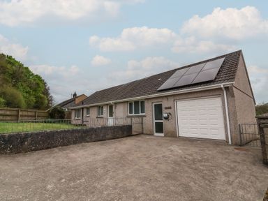 A bungalow with solar panels on the roof and a garage at West View in Northlew near Hatherleigh