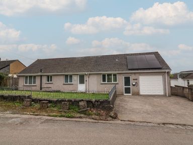 A bungalow with solar panels on the roof a front garden and a driveway at West View in Northlew near Hatherleigh