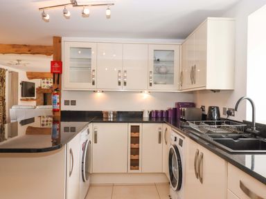 A kitchen with appliances and cabinets at Swallows Reach Halwell