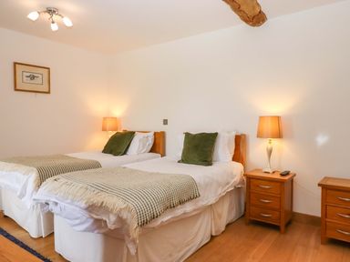 A bedroom with twin beds and nightstands at Swallows Reach in Halwell