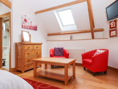 A living room with armchairs and a coffee table at Swallows Reach in Halwell