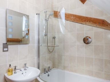 A bathroom featuring a shower and bathtub at Swallows Reach in Halwell