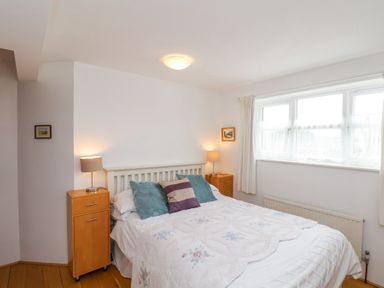 A bedroom with a double bed with pillows and lamps on wooden bedside cabinets at The Barn - Poplar Farm in Lower Dunsforth near Boroughbridge