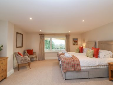 A bedroom with two beds side by side and two chairs near a window at Blossom Hill near Witney