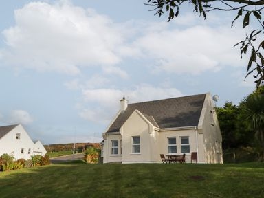 A house with a sloped roof and outdoor chairs on a grassy lawn at Horn Head View in Carrigart County Donegal