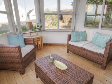 A sitting area with wicker armchairs and a coffee table with cushions and a lamp at Horn Head View in Carrigart County Donegal