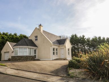 A detached house with a garage and driveway surrounded by trees and shrubs at Horn Head View in Carrigart County Donegal