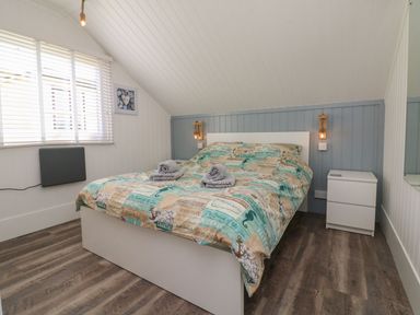 A bedroom with a bed a bedside table and window blinds at La Bella Vista in Kilkhampton