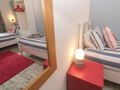 A bedroom with two beds and a wardrobe at The Packing House in Rosudgeon