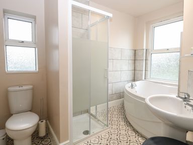 A bathroom with a toilet a shower cubicle a bathtub and a sink at Grosvenor House in Kirkley Rise
