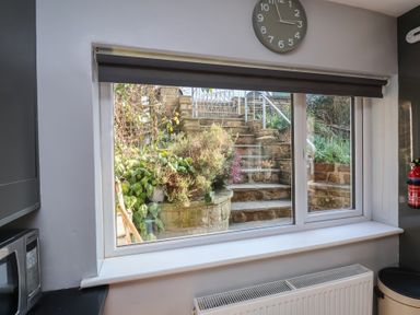 A kitchen window showing stone steps and garden plants outside at Trackside in Ruswarp