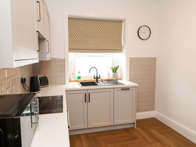 A kitchen with a sink and microwave at Flat 1 Rhos-On-Sea