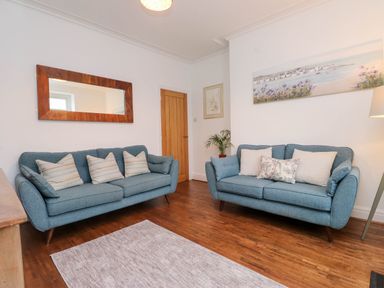 A living room with sofas and a rug at Flat 1 Rhos-On-Sea