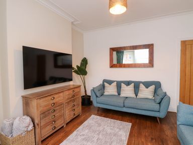 A living room with a television and sofa at Flat 1 in Rhos-On-Sea