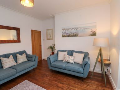 A living room with two sofas and a lamp at Flat 1 Rhos-On-Sea