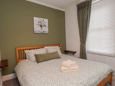 A bedroom with a bed and decorative items at Flat 1 Rhos-On-Sea