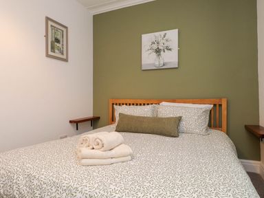 A bedroom with a bed and towels on it at Flat 1 in Rhos-On-Sea