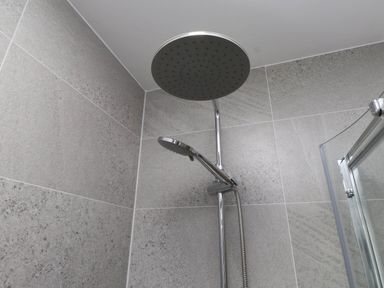 A shower area with a rainfall shower head and handheld shower at Flat 1 Rhos-On-Sea