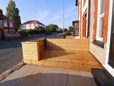 A wooden decking area next to the street at Flat 1 Rhos-On-Sea