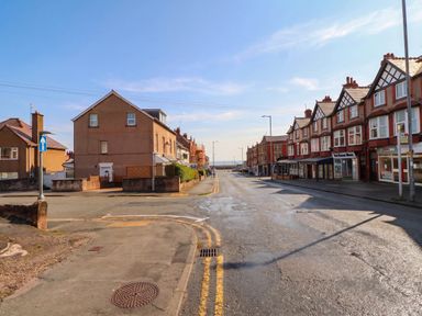A street view with residential buildings and ocean in the background at Flat 1 Rhos-On-Sea