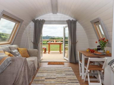 A living room with a sofa and table at Under Oak Pod in Totnes