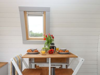 A kitchen table with food and drinks at Under Oak Pod in Totnes