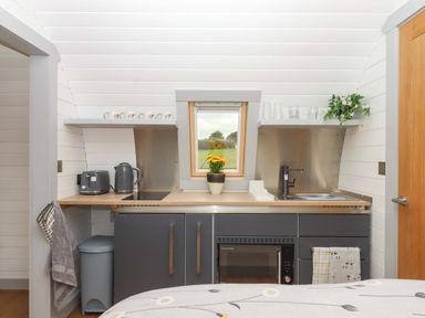 A kitchen area with sink and cupboard at Under Oak Pod Totnes