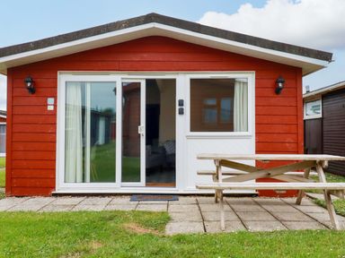 A cabin exterior with a picnic table at H2 Atlantic Bay Holiday Park in Padstow