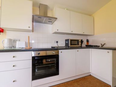 A kitchen with appliances and cabinets at H2 Atlantic Bay Holiday Park in Padstow